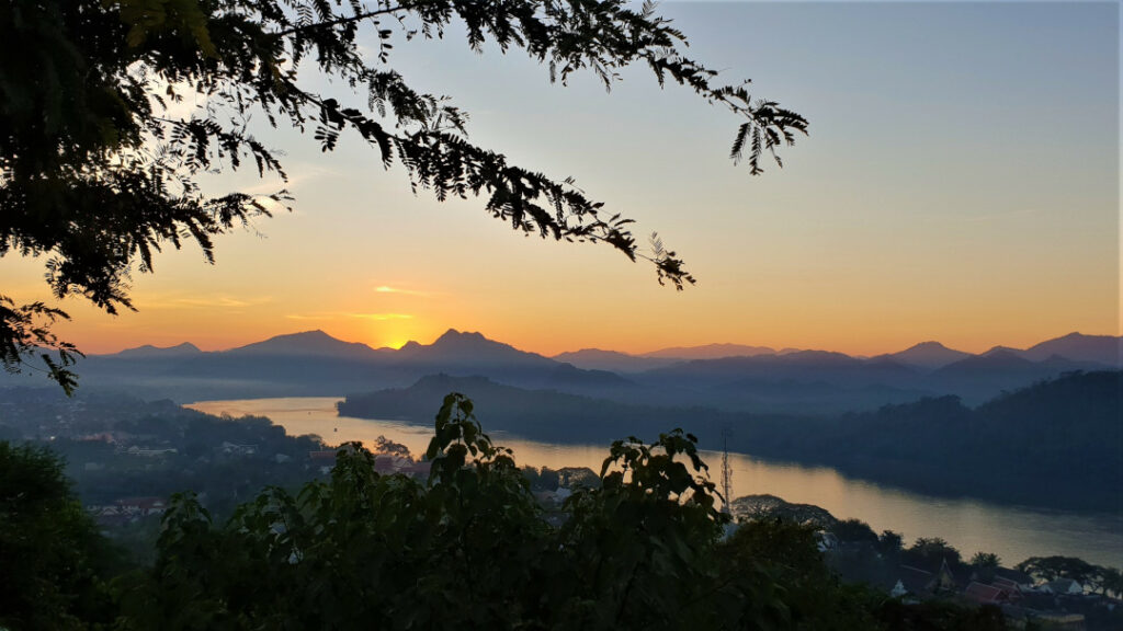 The sun nearly disappearing behind the mountains