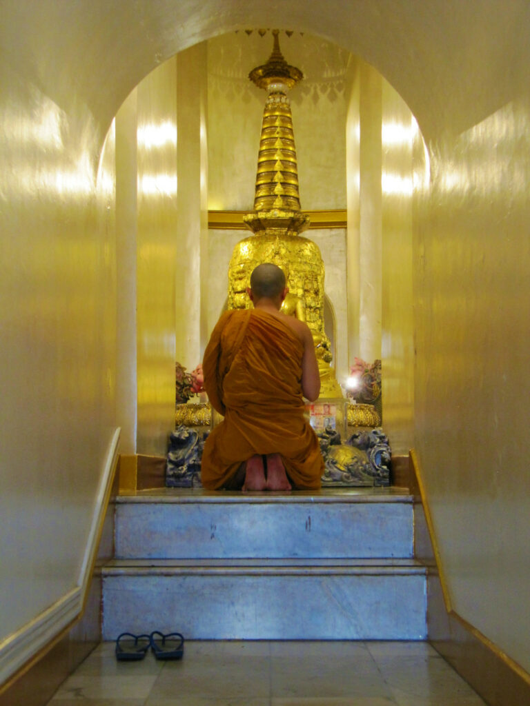 Buddhist monk praying inside Golden Mount