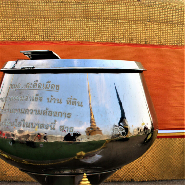 Stupa reflects on a donation collection box on the Golden Mount