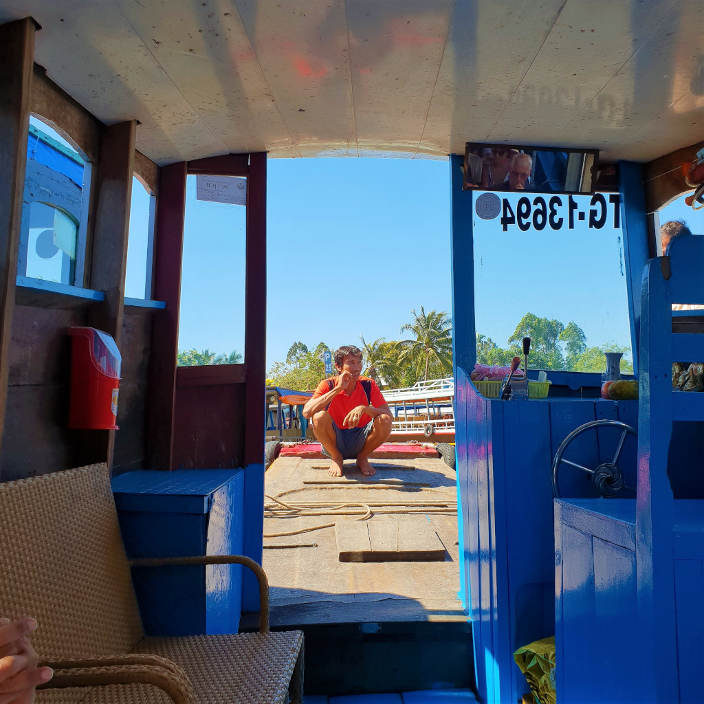 Captain of the boat taking a break while waiting for tourists to come back from their tour of the Mekong Delta