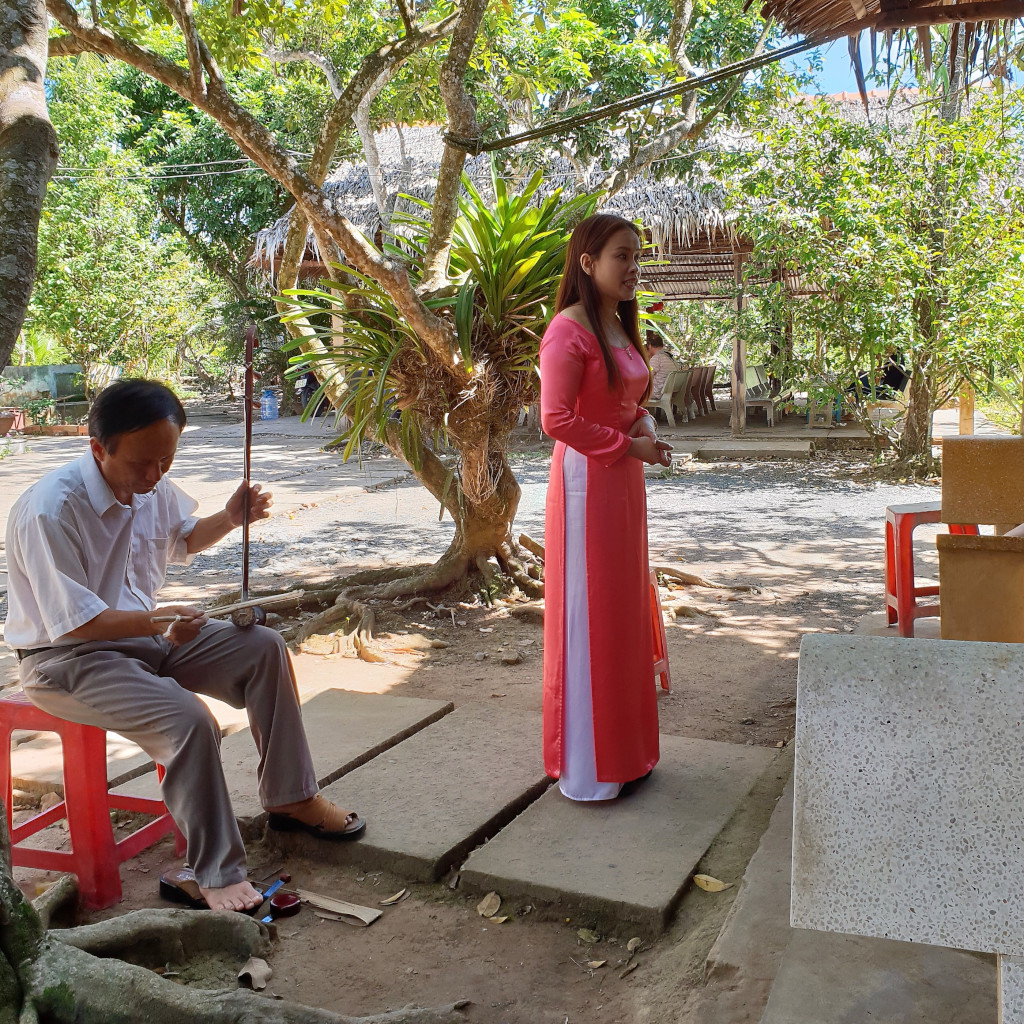 Singer entertaining tourists with folk songs in a Mekong Delta village