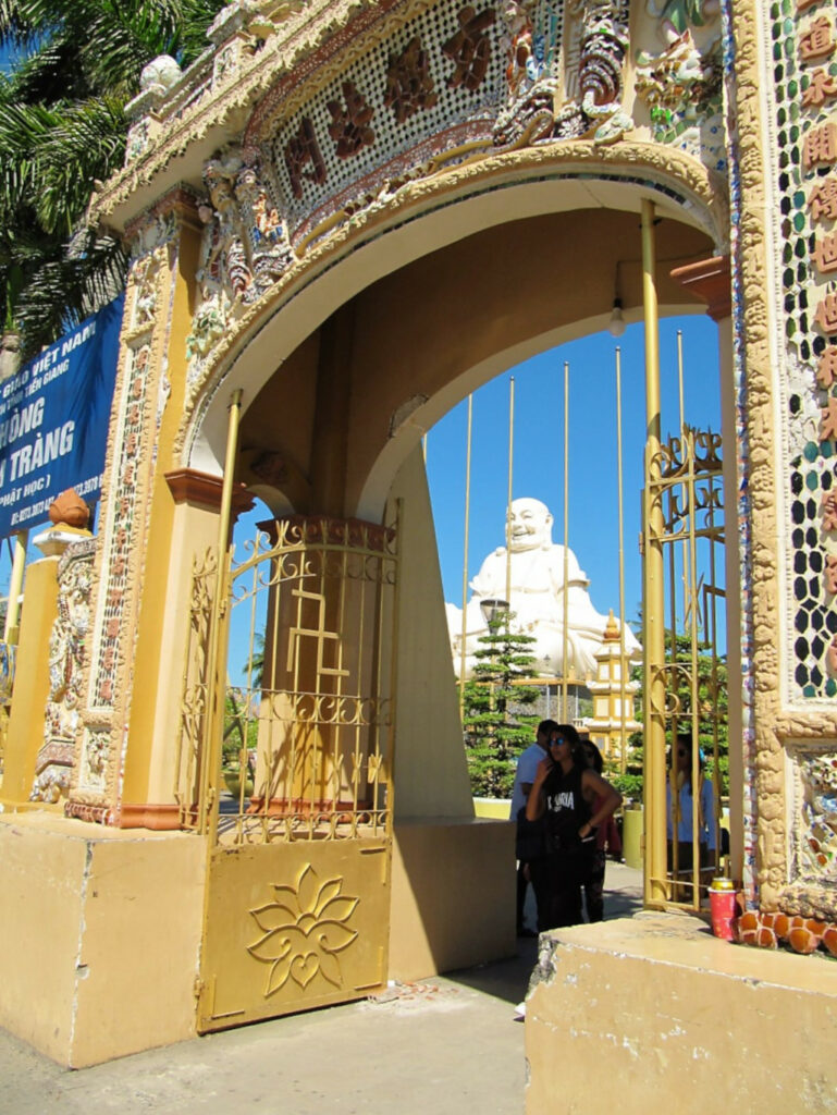 View of the smiling Buddha at Vinh Tranh pagoda from outside the gate
