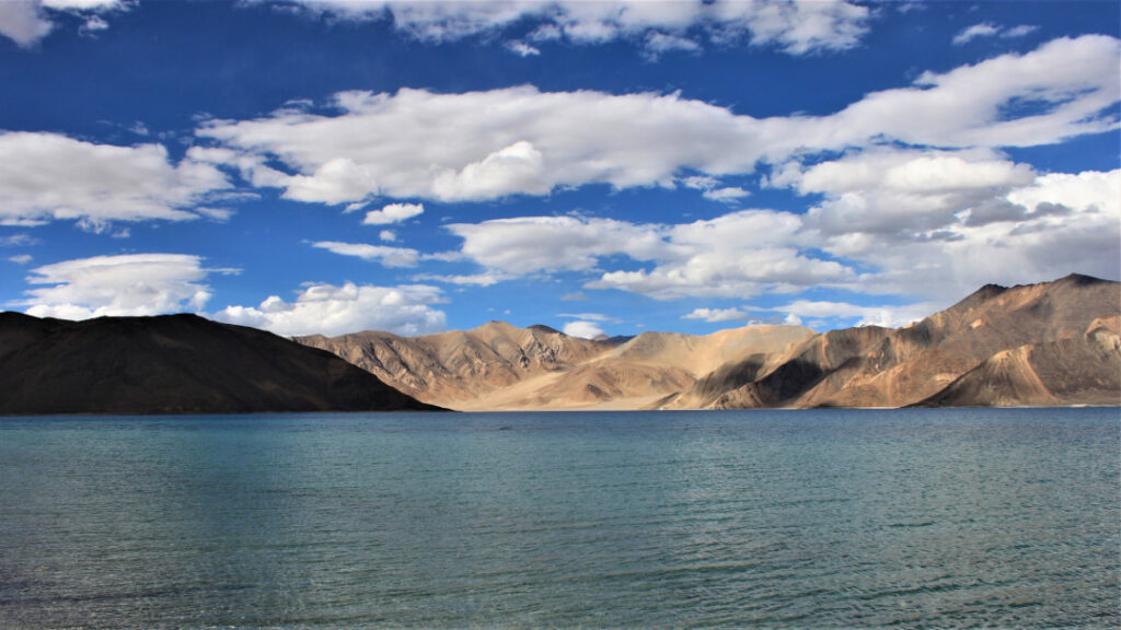 A panoramic view of Pangong Lake with the rugged mountains in the background