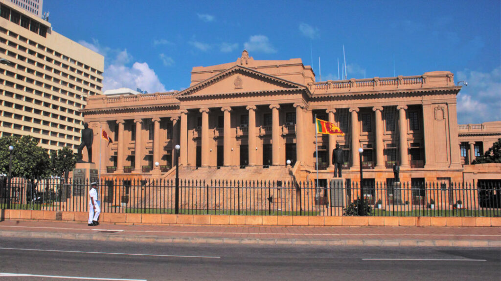 A naval officer walks past the old Parliament Building