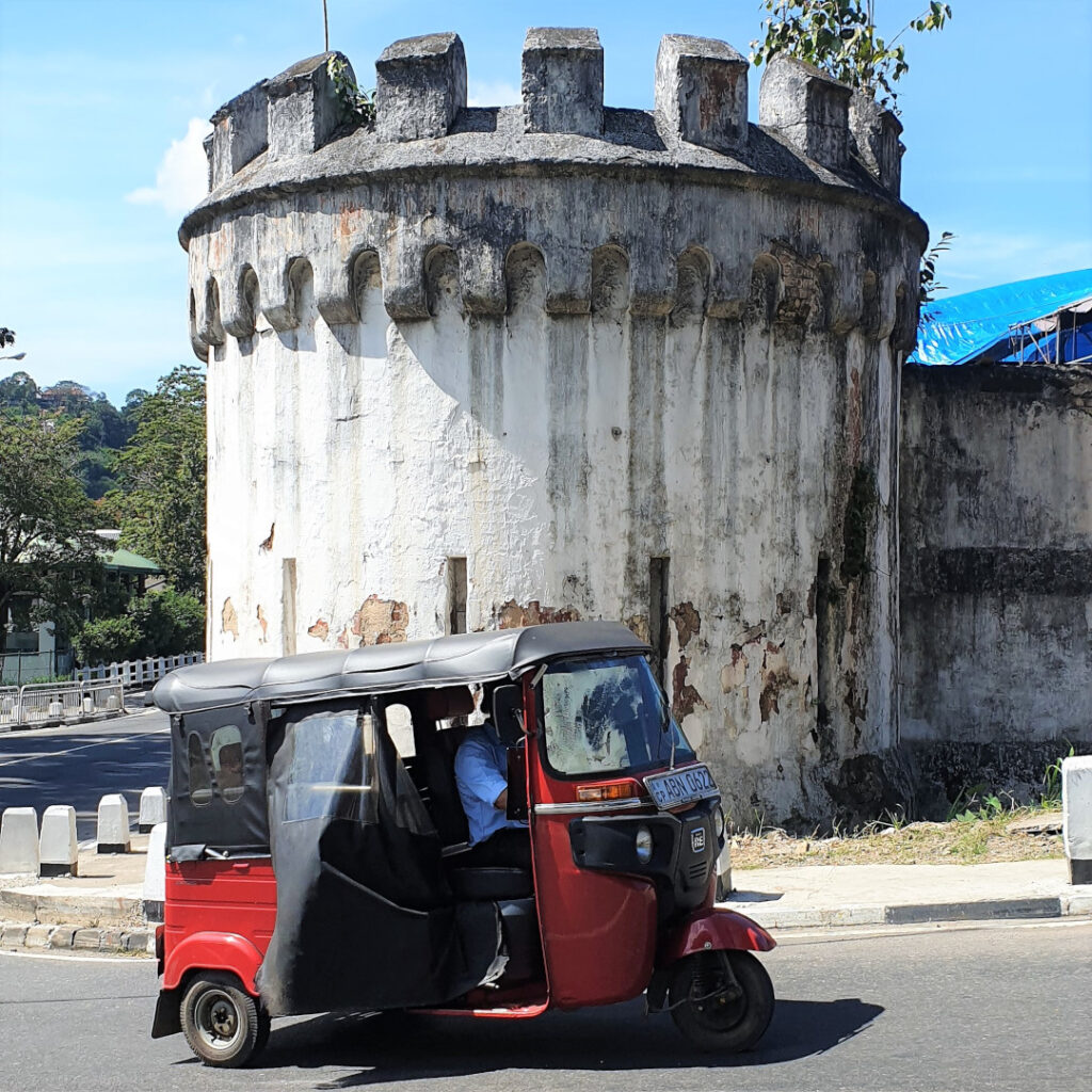 A tuk-tuk passes by the former prison